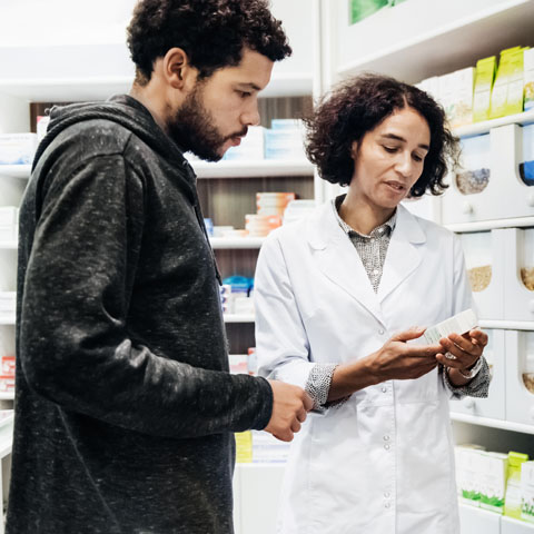 Pharmacist Helping Customer With Healthcare Products A pharmacist helping a customer with some different healthcare products in a city pharmacy.