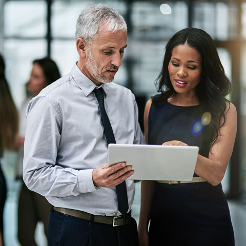 Teamwork and technology, indispensable tools for corporate productivity Shot of two professional coworkers using a digital tablet together at work